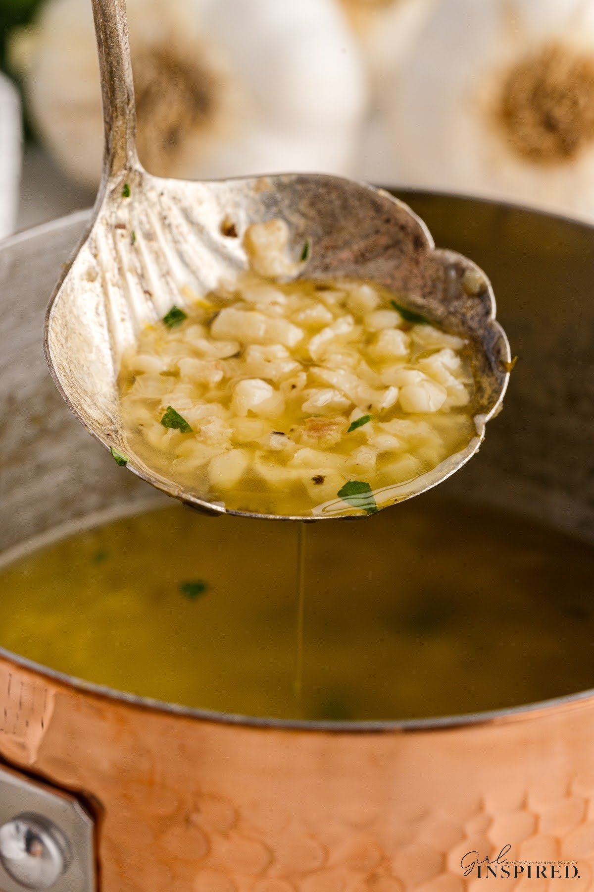 Garlic Butter Sauce on a spoon over a pot.