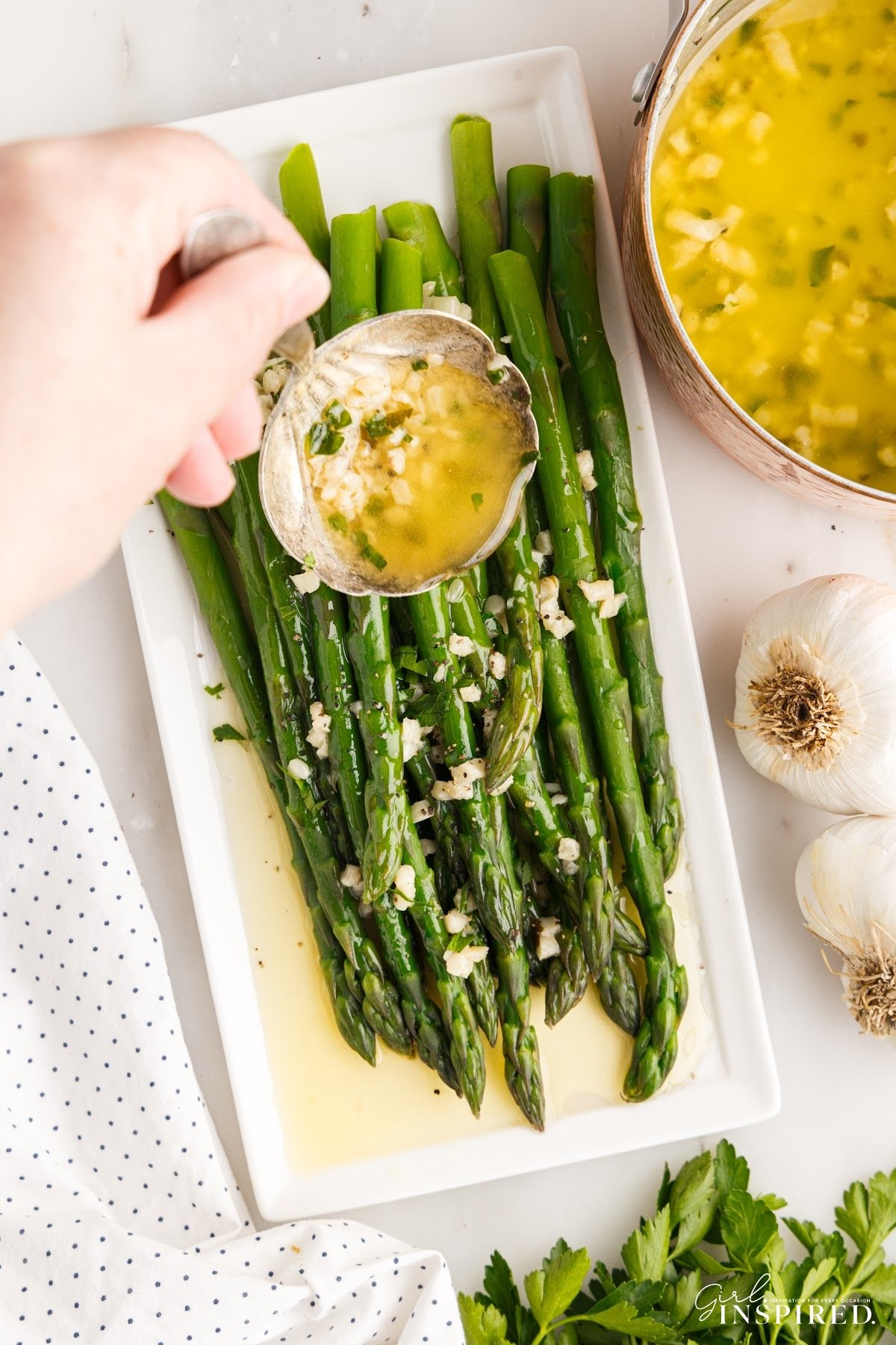 Garlic Butter Sauce poured over asparagus on a dish.