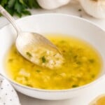 A close up of Garlic Butter Sauce with a spoon inserted.