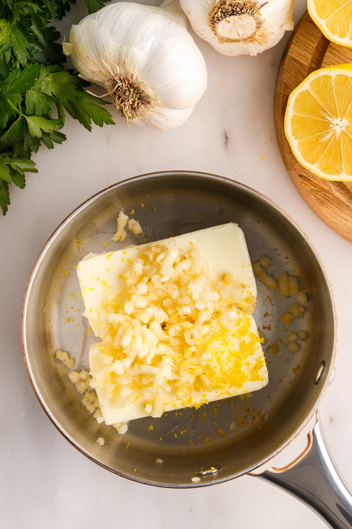 Butter in a sauce pan with garlic on top.