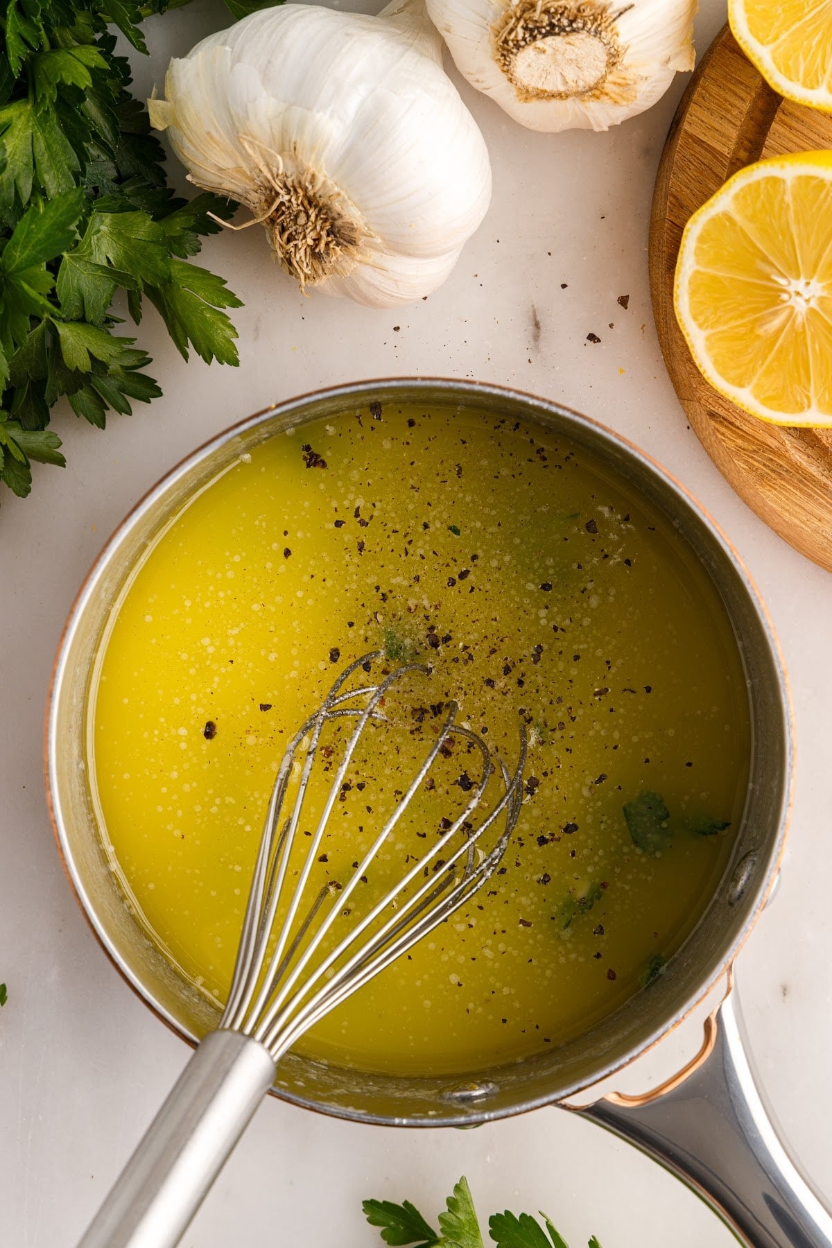 Salt and pepper added to a sauce pan of Garlic Butter Sauce.