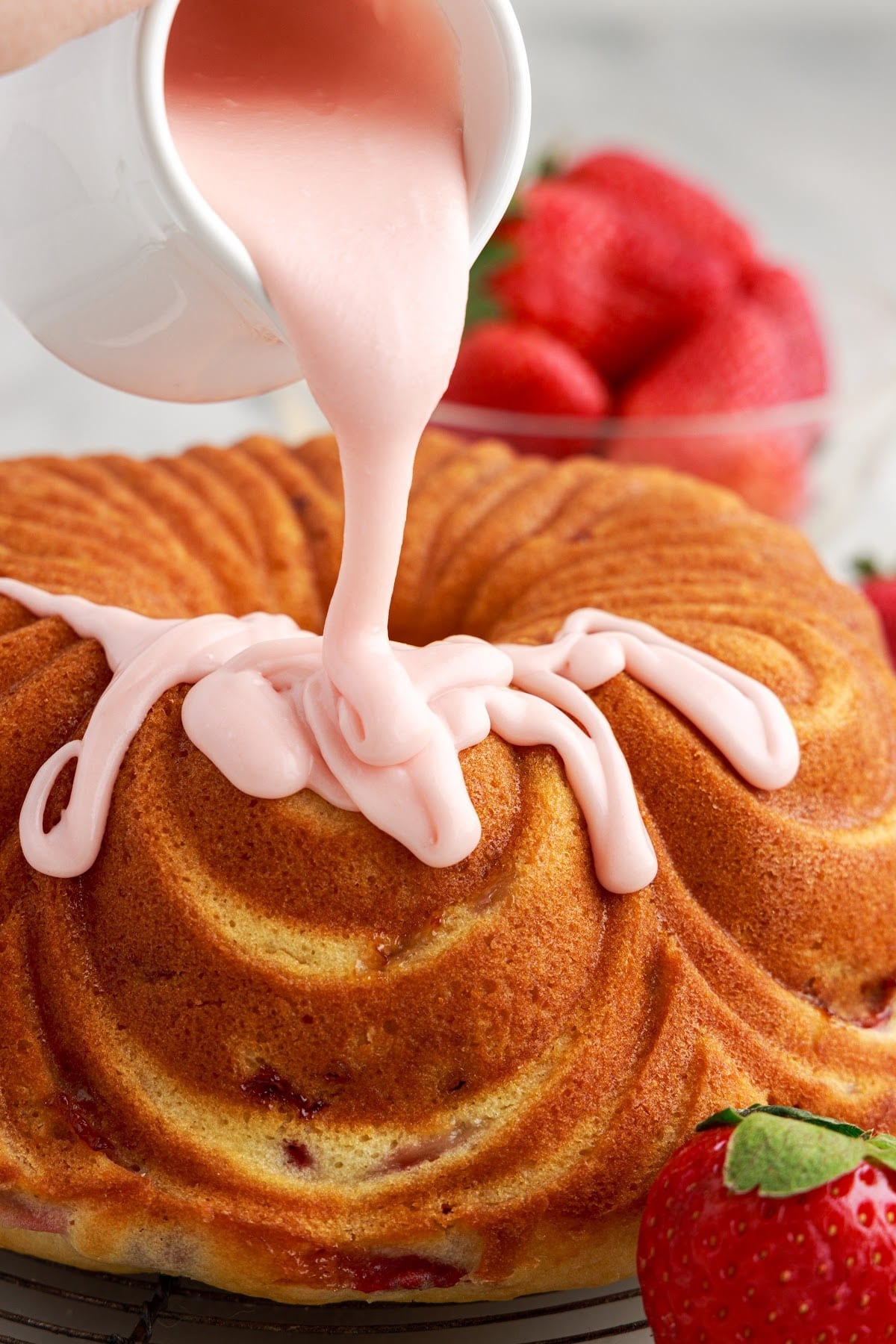 Strawberry Bundt Cake with glaze poured on top of it.