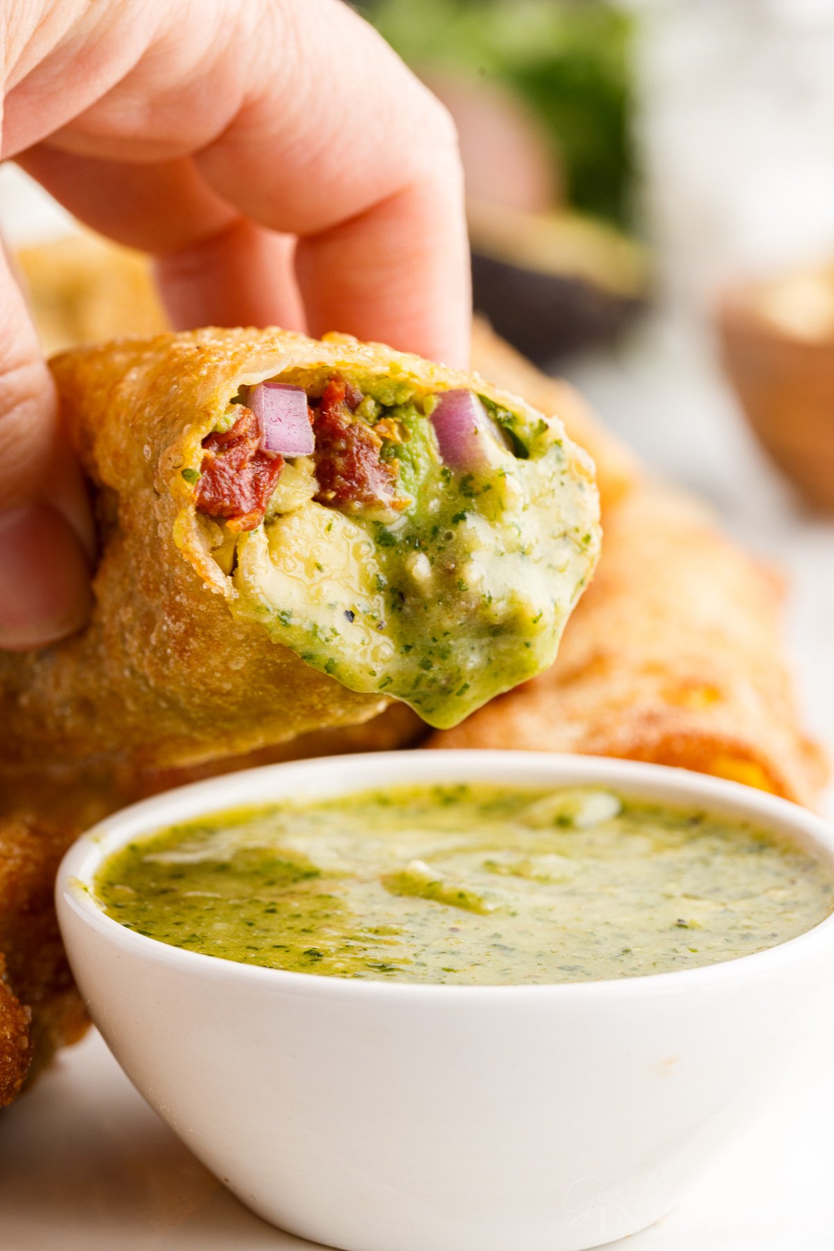 Cheesecake Factory Avocado Egg Rolls dipped in sauce.