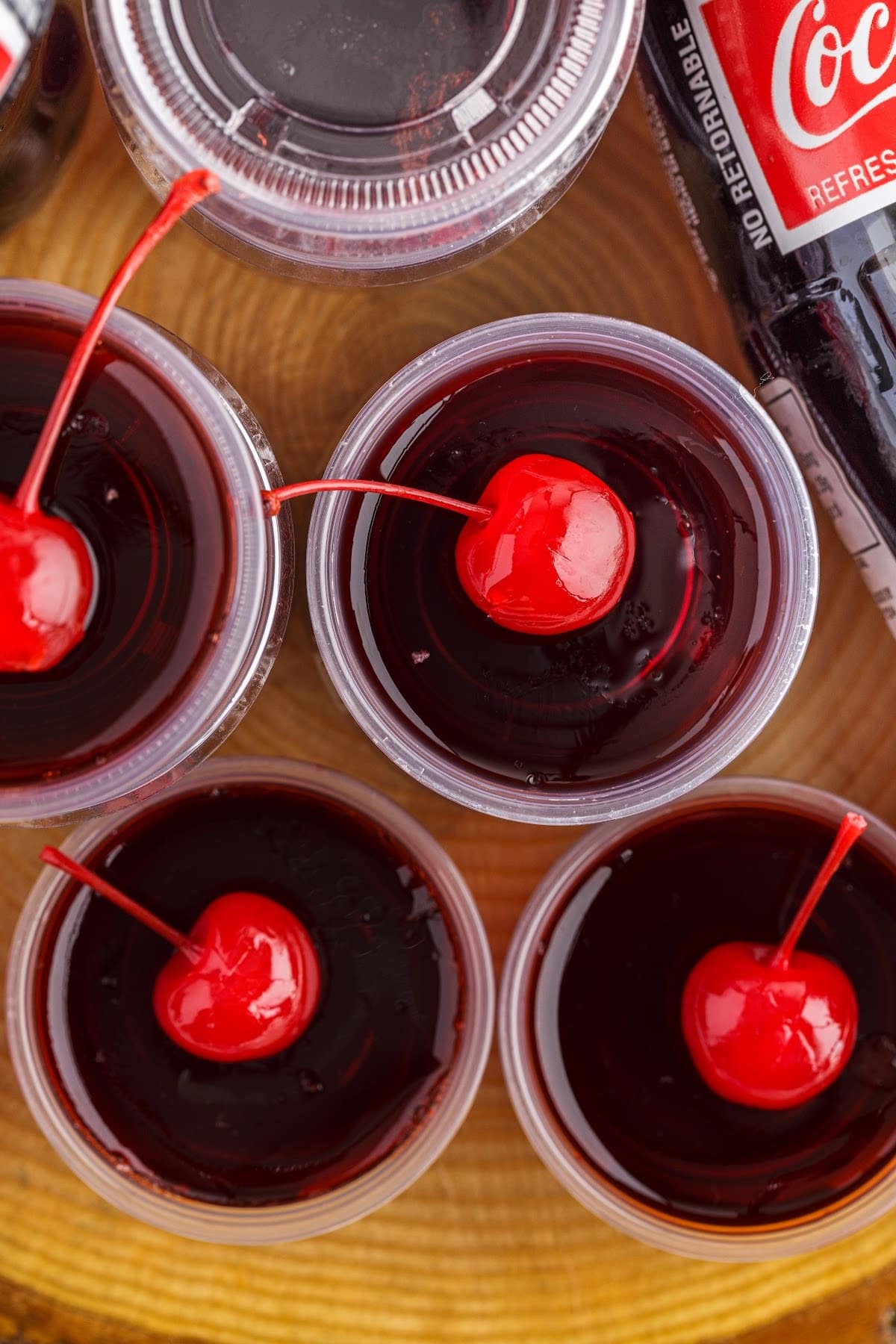 Overhead close up of Cherry Coke Jello Shots topped with cherries.