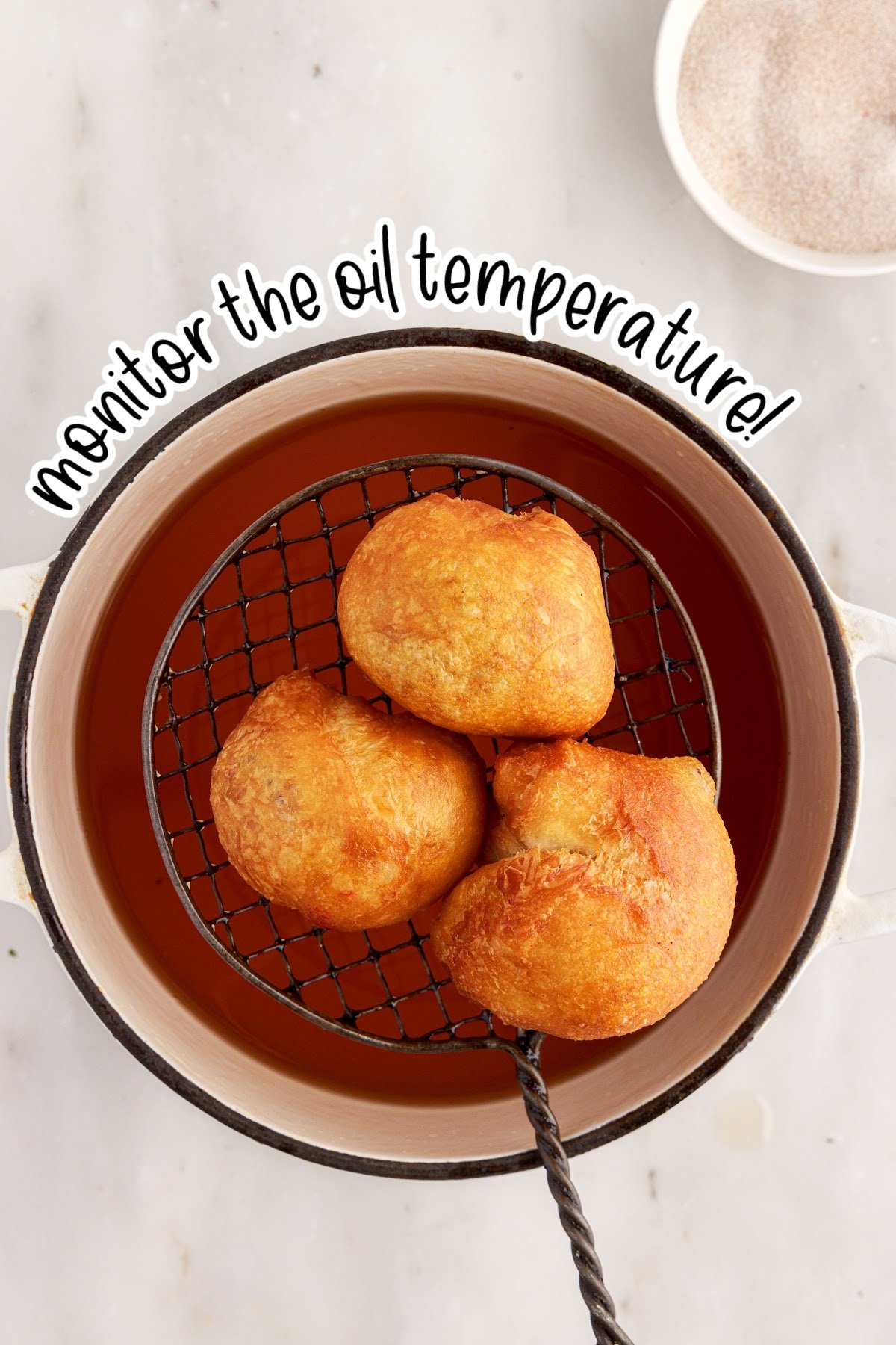 Three Apple Pie Bombs on a wire strainer over oil with text overlay.