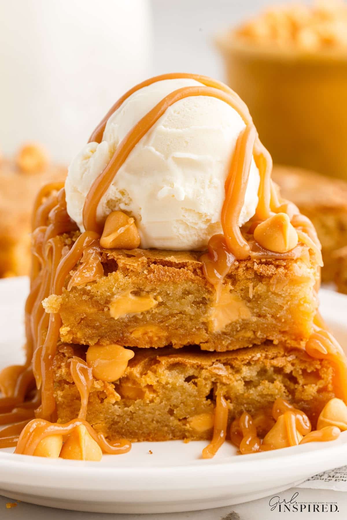 Two Butterscotch Blondies with a scoop of ice cream on the top.