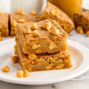 Front view of two Butterscotch Blondies stacked on each other on a small dish.