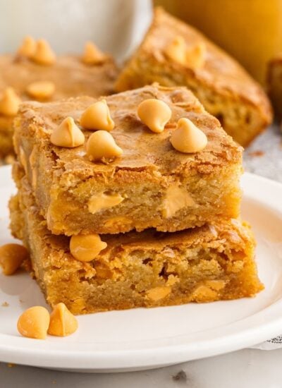 Front view of two Butterscotch Blondies stacked on each other on a small dish.