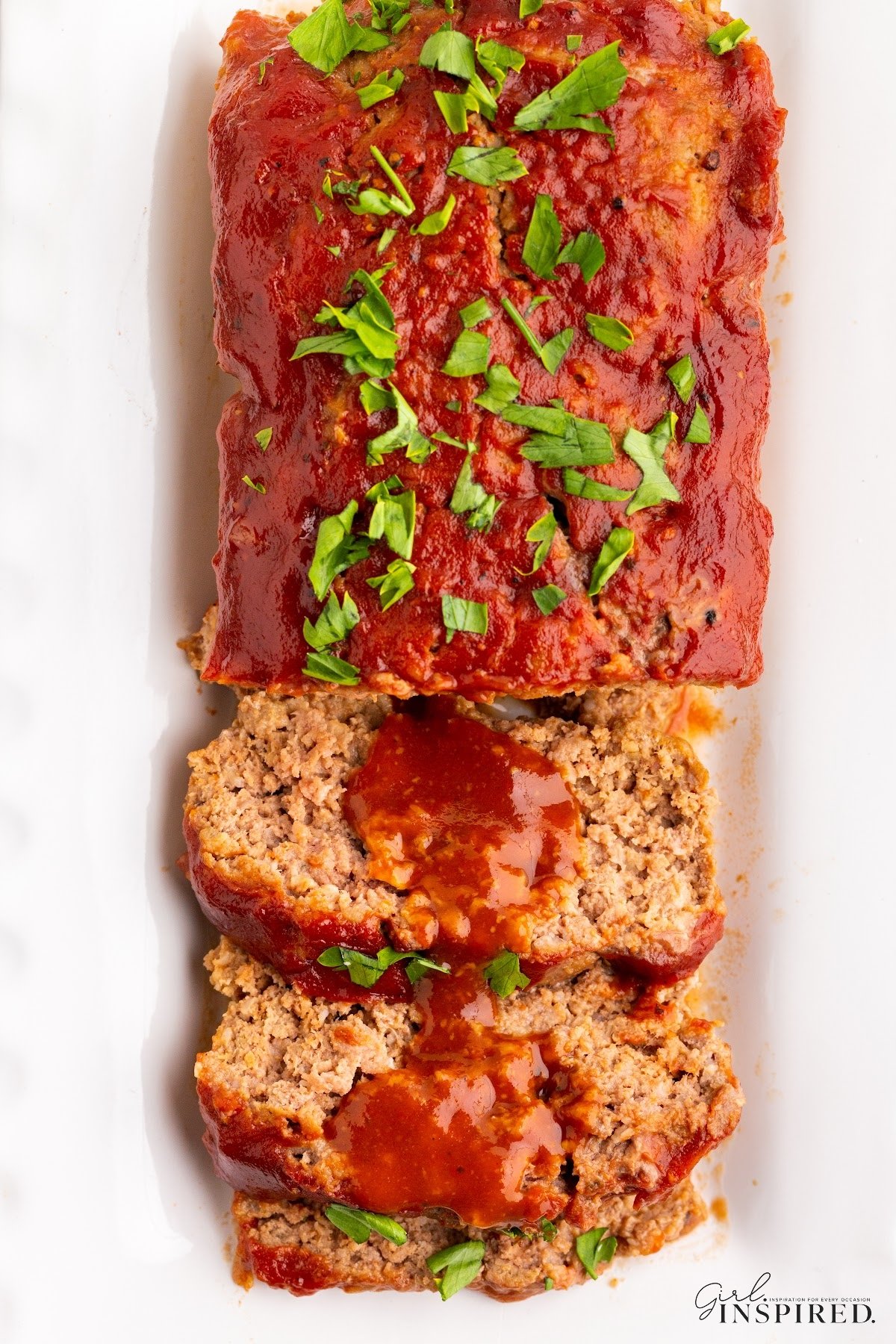 Overhead view of Mama's Meatloaf on a platter with slices cut.