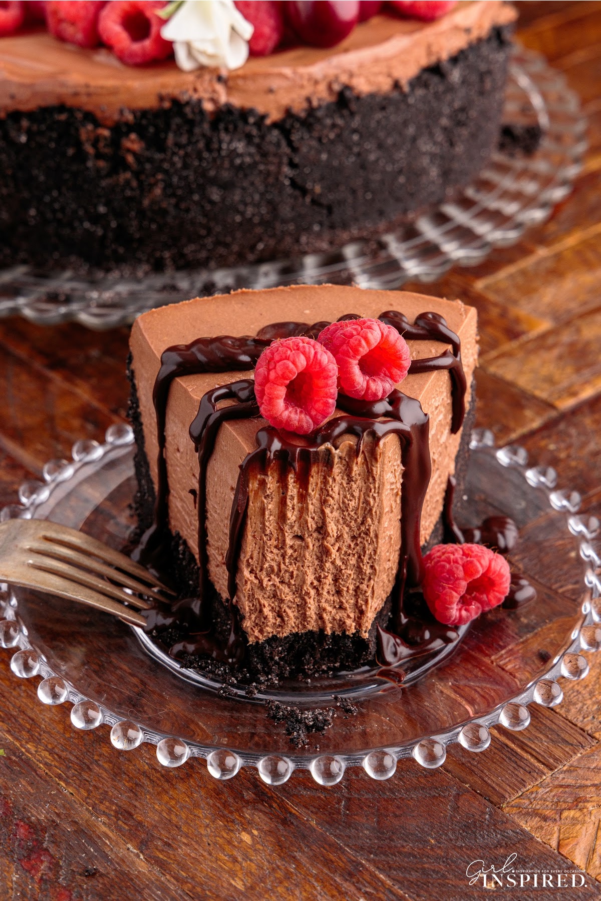 A slice of No Bake Chocolate Cheesecake with a bite missing topped with raspberries.