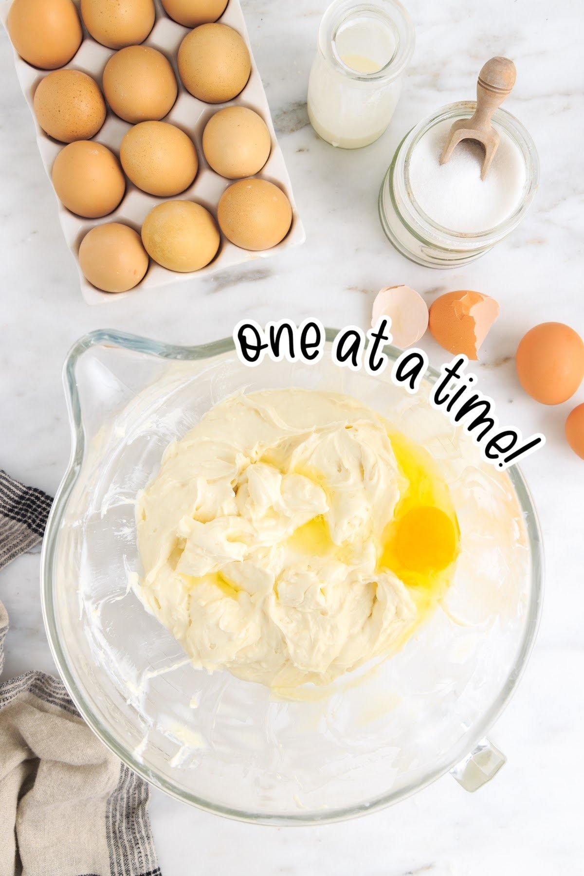 Eggs added to cream cheese mixture one at a time with text overlay.