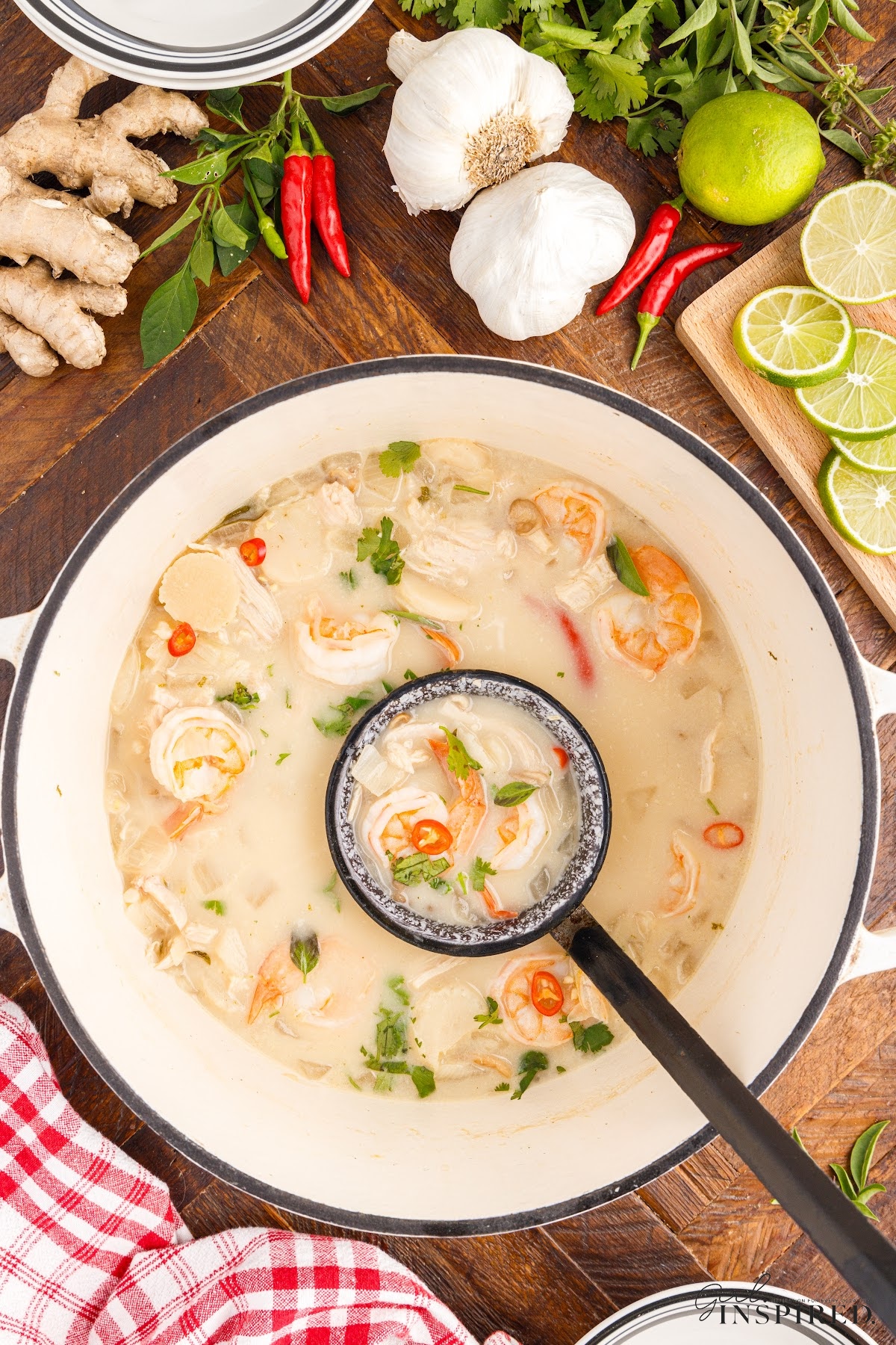 An overhead view of a pot of Thai Coconut Soup some on a ladle.