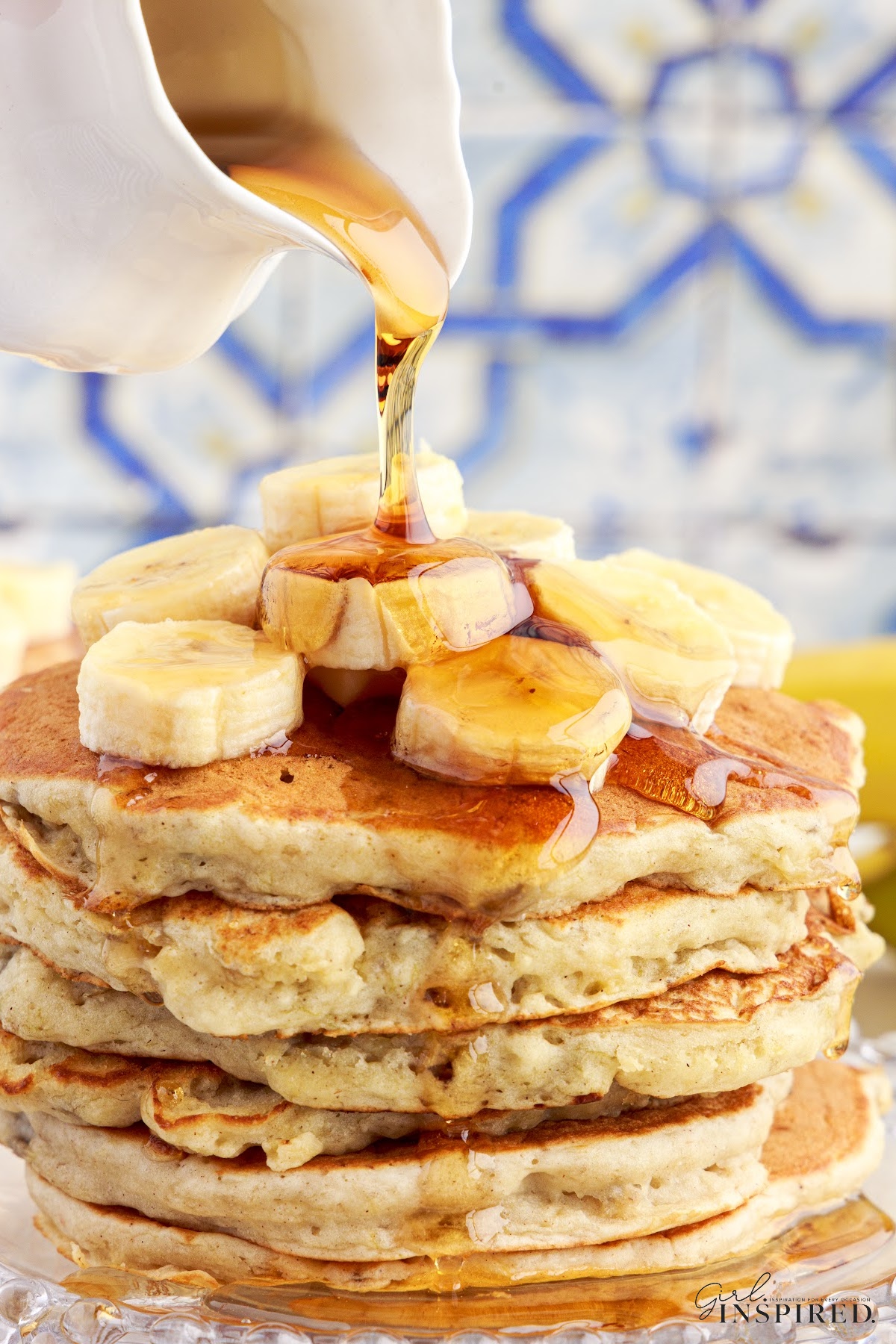 Syrup poured on top of a stack of banana buttermilk pancakes.