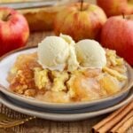 Front view of a serving of Apple Pie Dump Cake with ice cream on a dish.