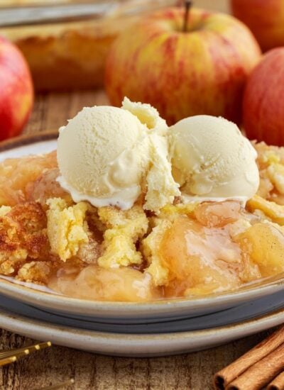 Front view of a serving of Apple Pie Dump Cake with ice cream on a dish.