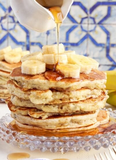 Syrup poured on top of a stack of banana buttermilk pancakes.
