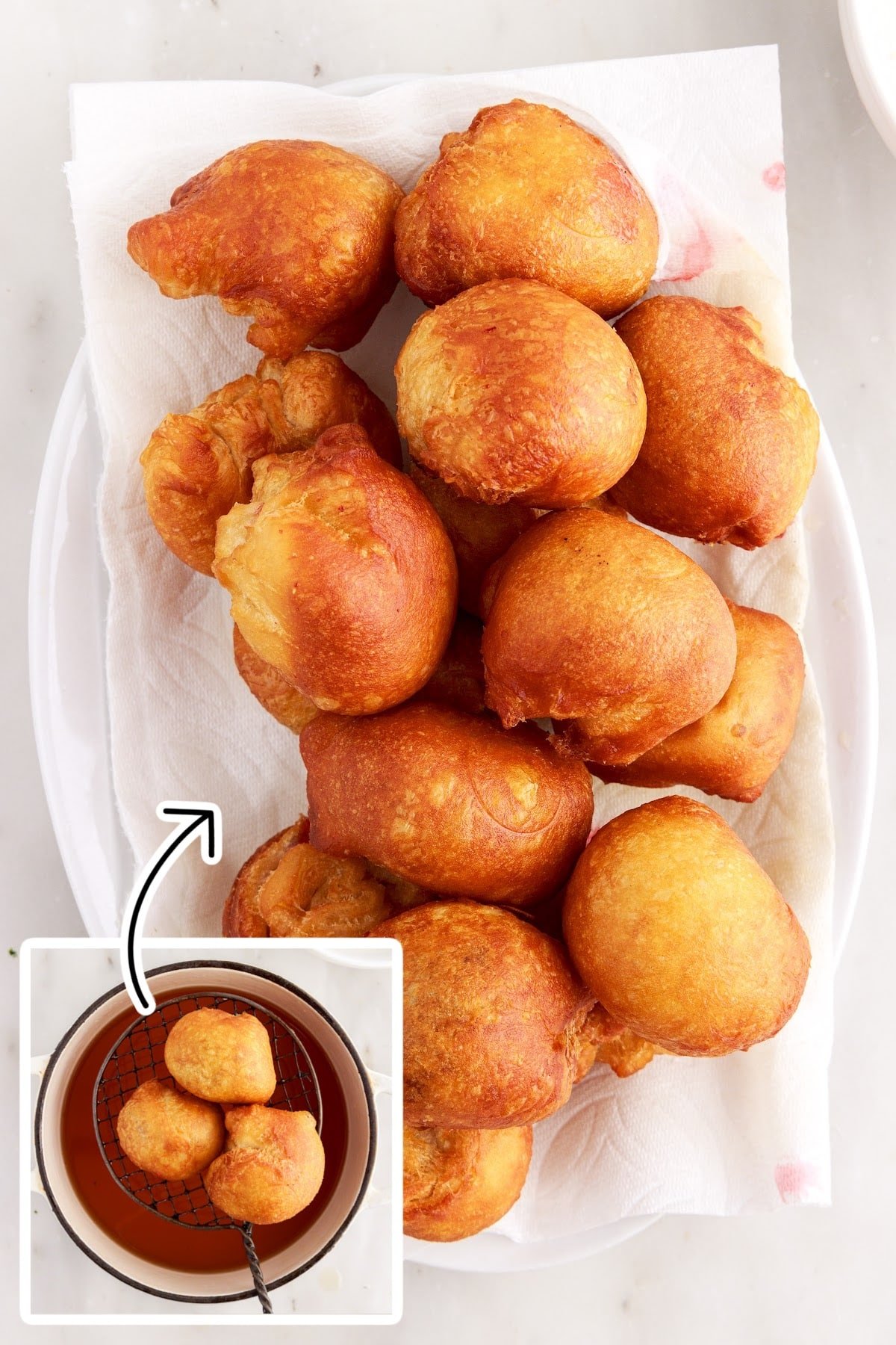 Cherry Pie Bombs lifted from air fryer and stacked on a paper towel lined tray.