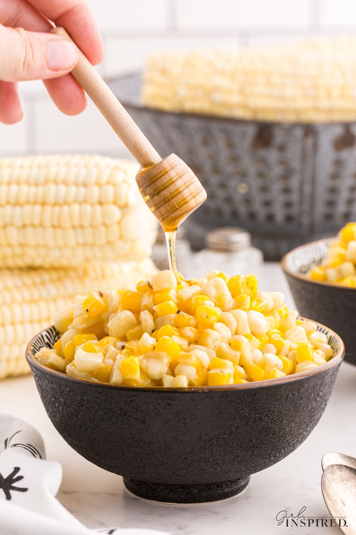 Honey Butter Skillet Corn in a small dish with honey drizzled on top.