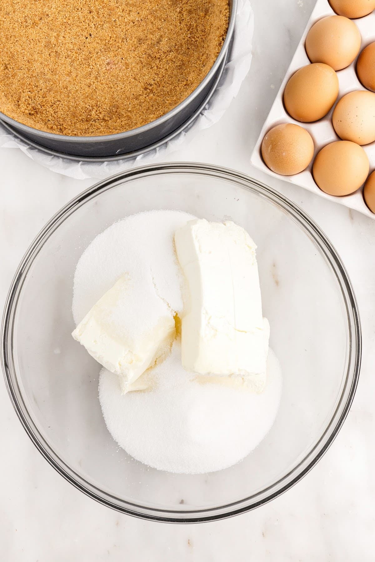 Sugar and cream cheese in a mixing bowl.