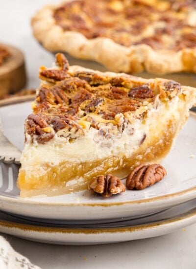 Front view of a slice of Pecan Cheesecake Pie on a plate.