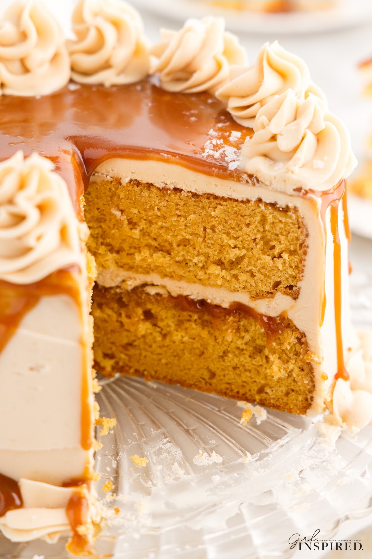 Front close up of a Salted Caramel Cake with a slice missing.