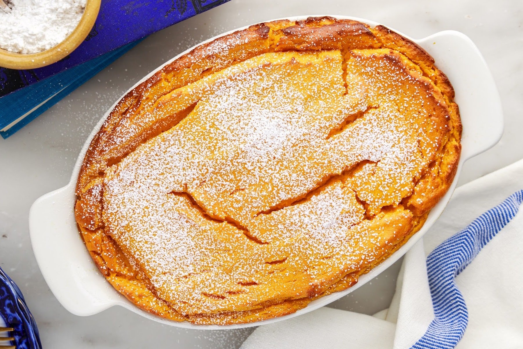 Overhead close up of a crockpot of Carrot Souffle dusted with powdered sugar.