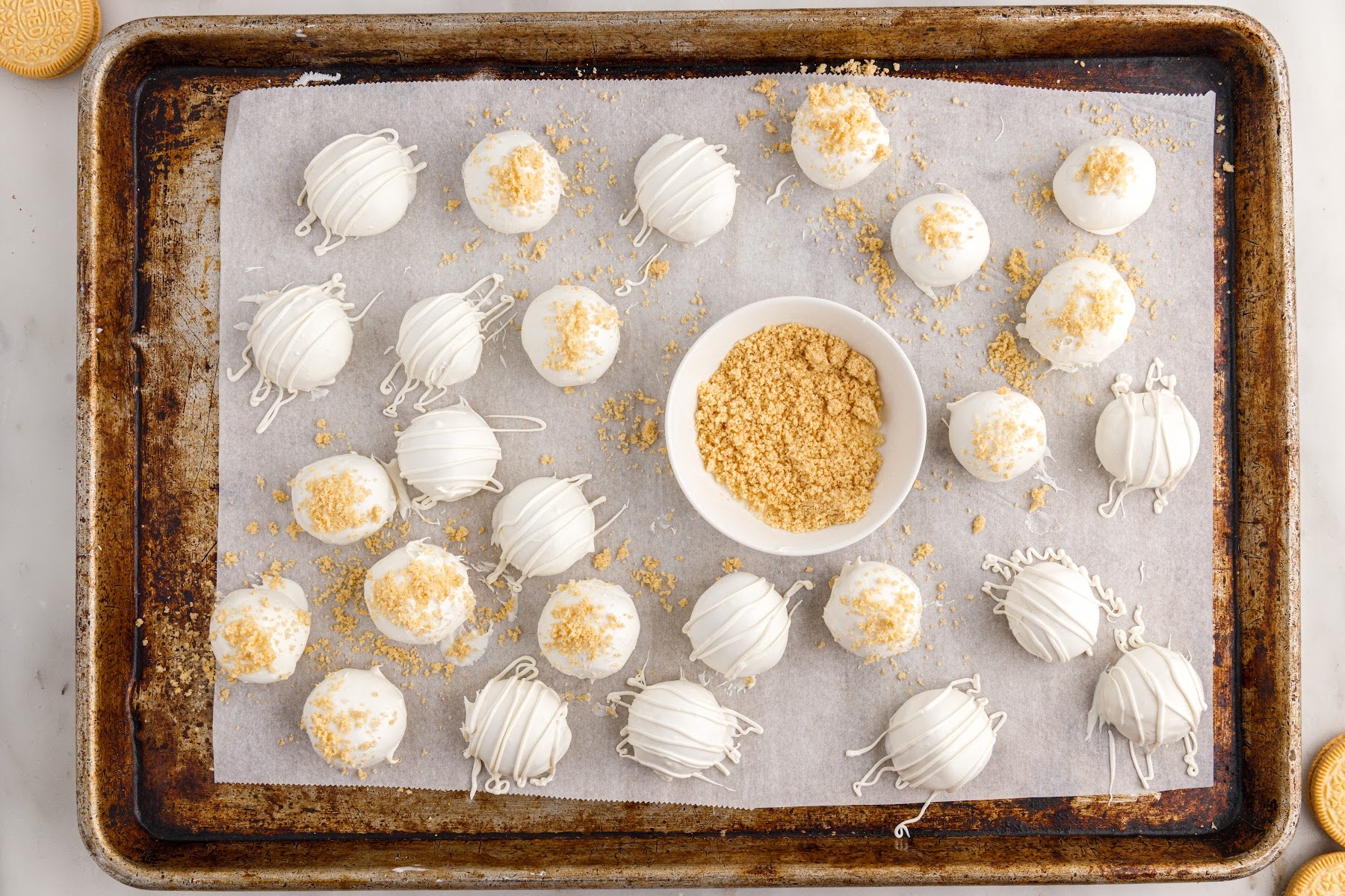 Golden Oreo Truffles on a parchment paper lined cookie sheet.
