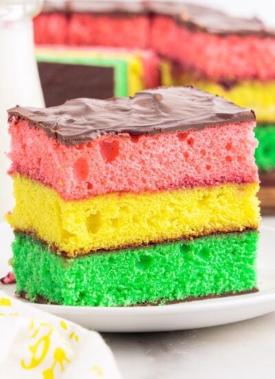 A plate with a slice of Italian Rainbow Cake on it.