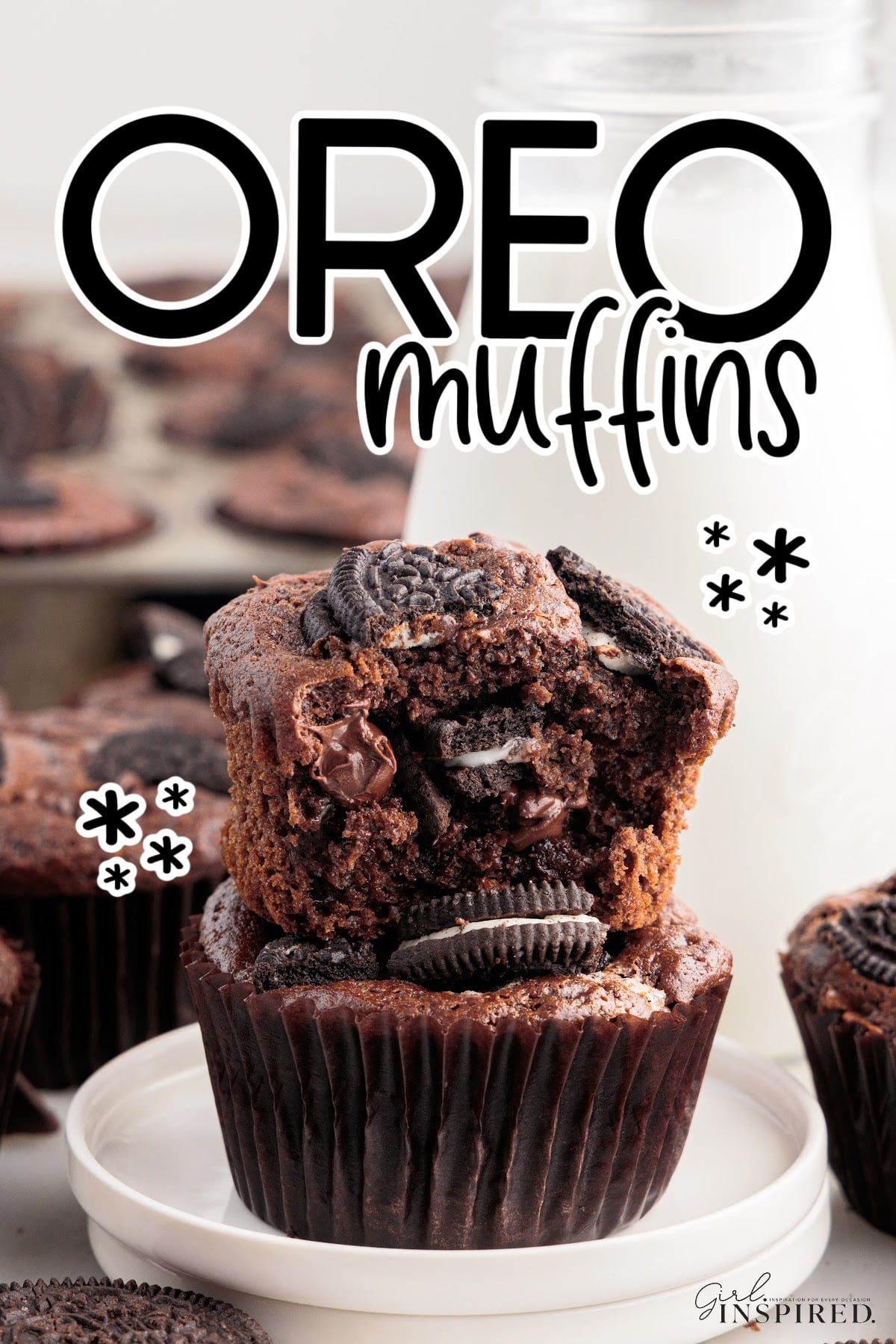 Oreo Muffins stacked on each other with a bite taken from the top one.
