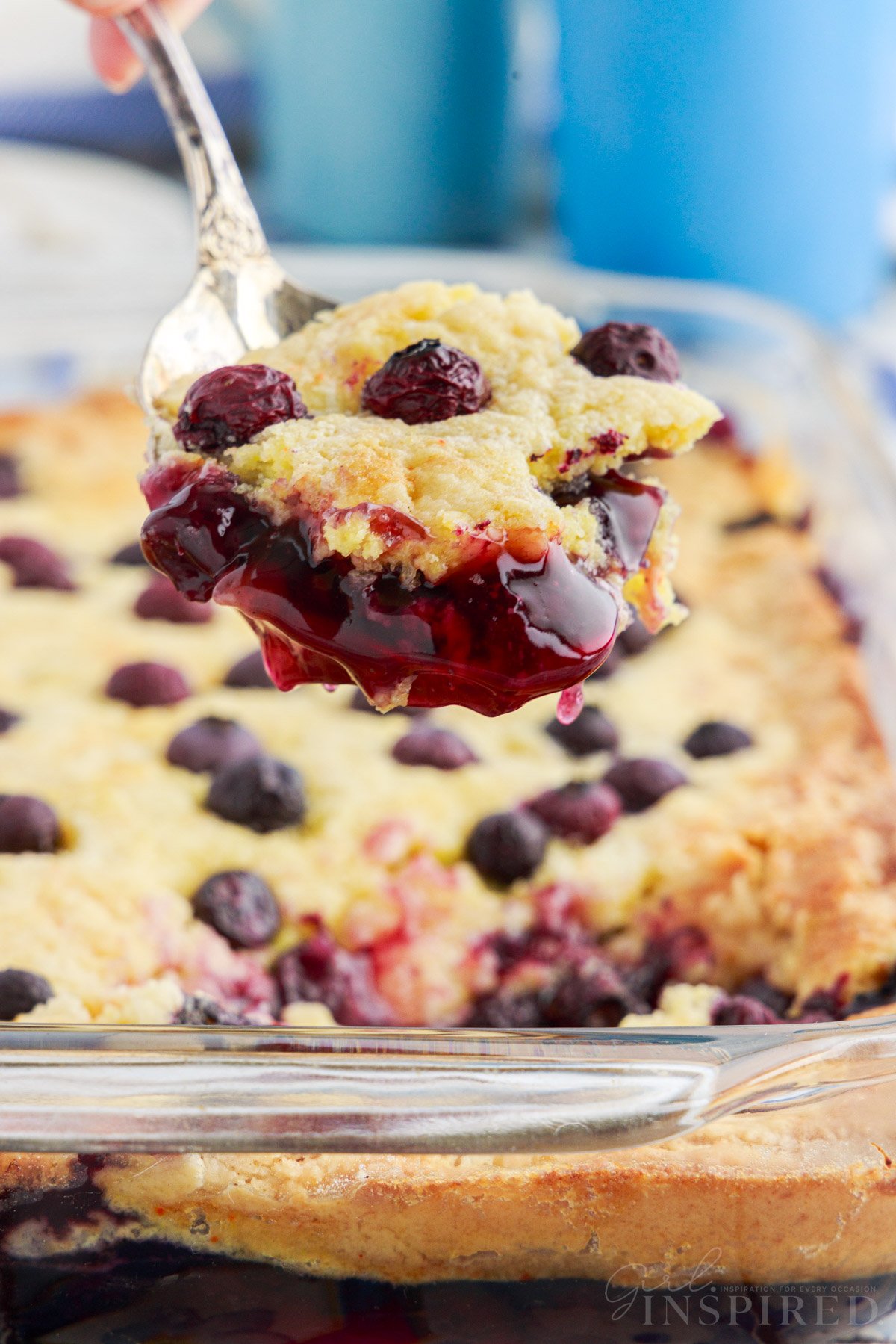 A spoonful of Blueberry Dump Cake over baking dish.