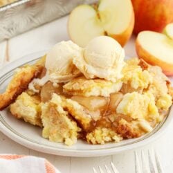 Close up of a plate of Apple Cream Cheese Dump Cake with ice cream on top.