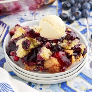 Close up of a serving of Blueberry Dump Cake with a scoop of vanilla ice cream.