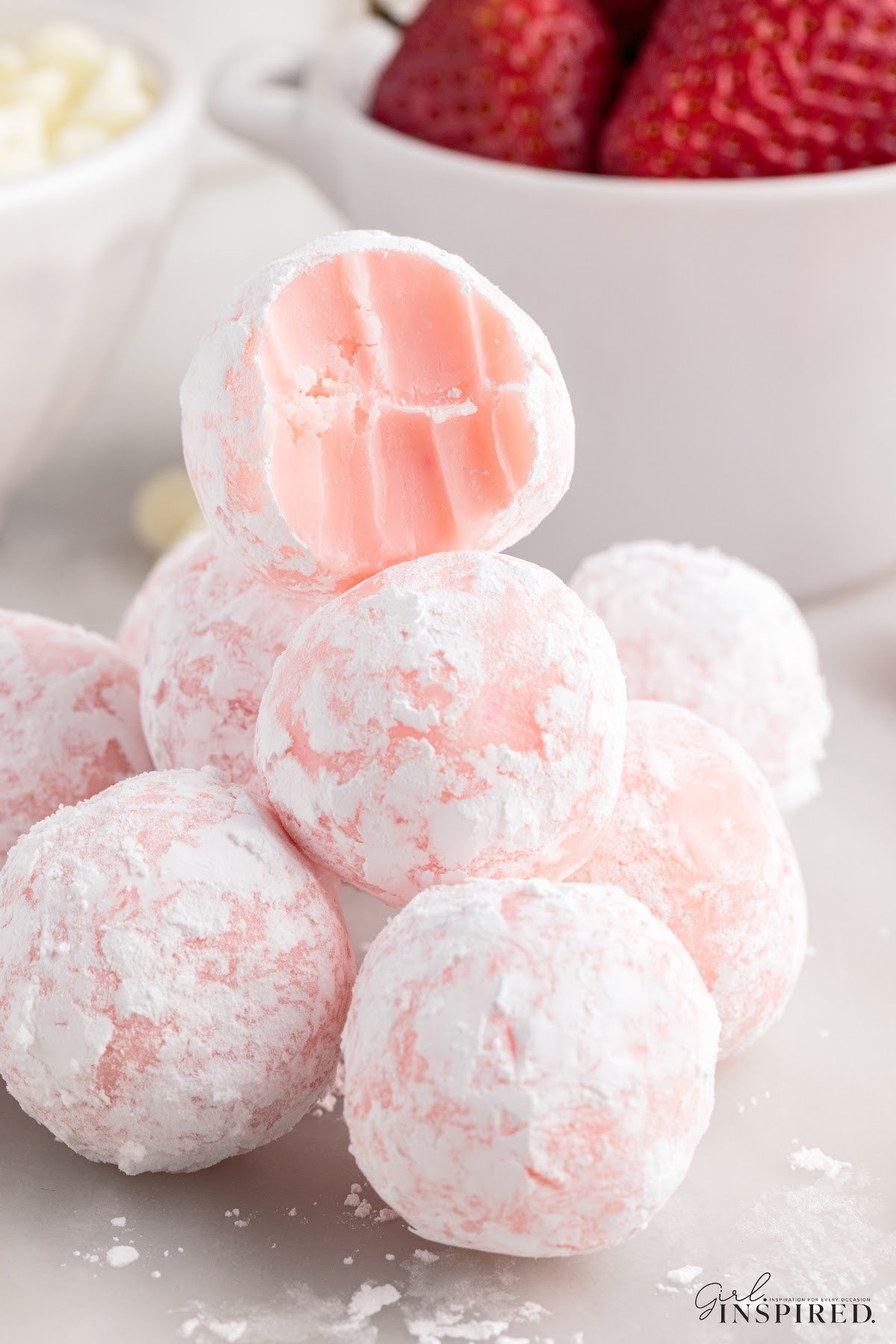 A stack of Strawberry Truffles with one on top with a bite out of it.