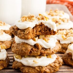 Carrot Cake Cookies with frosting on top and a bite out of the top cookie.