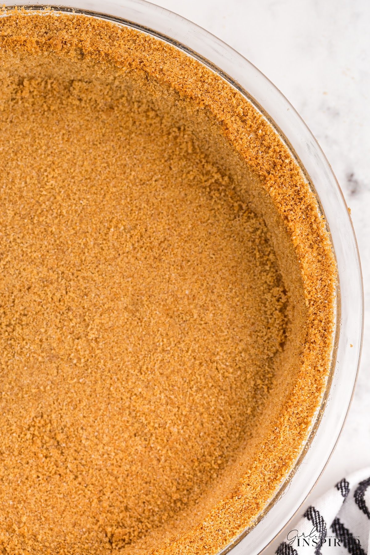 Top view of the graham cracker pie crust in a glass dish.