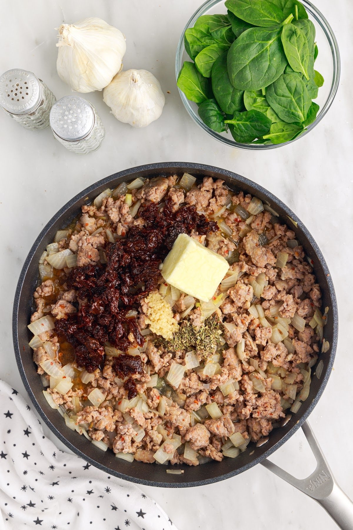 Browned Italian sausage, seasoning, garlic, butter, and sundried tomatoes in a large skillet.