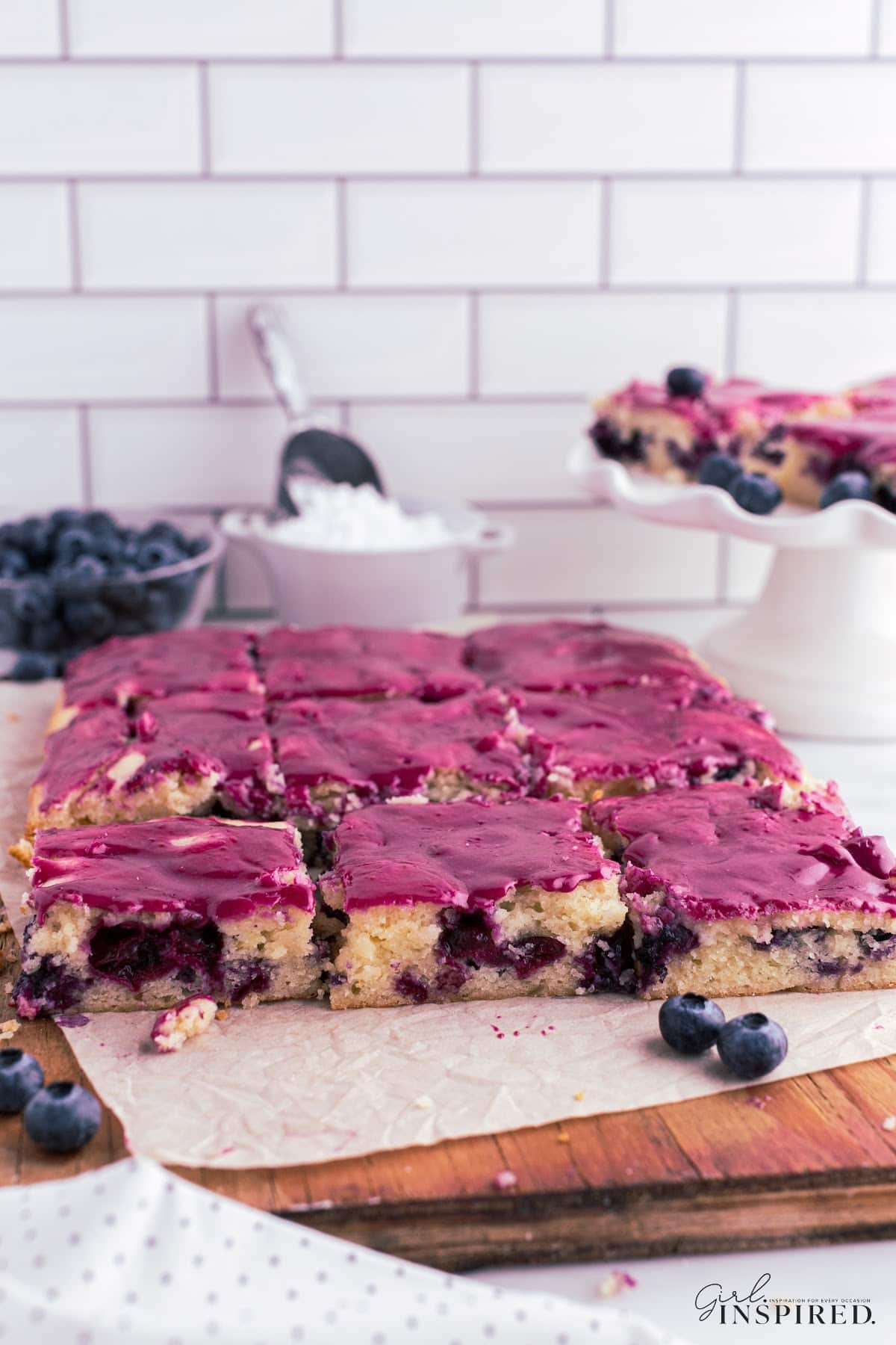 Completed Lemon Blueberry Blondies on a cutting board, cut and ready to serve.