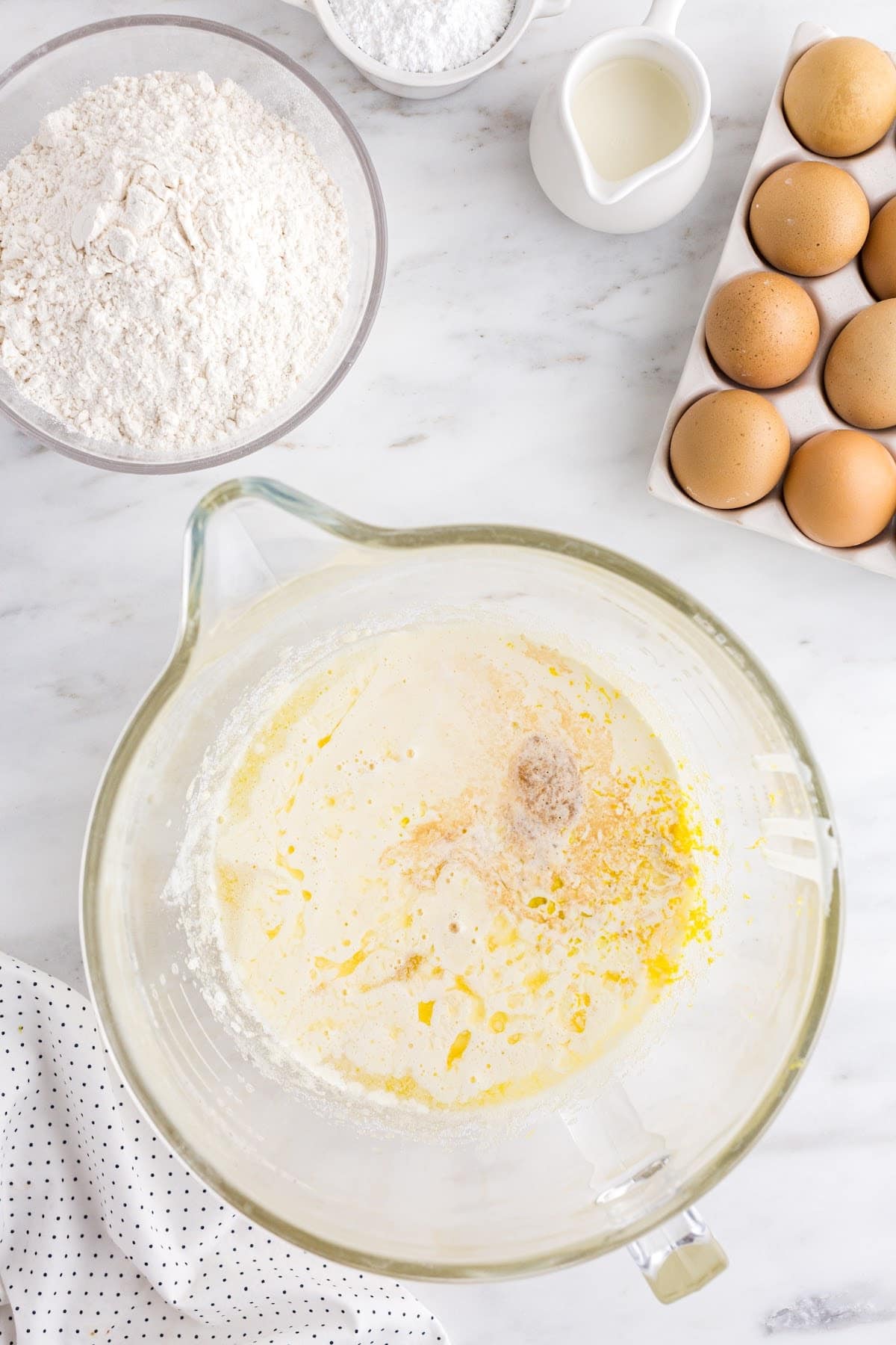 Melted butter, lemon juice, vanilla extract, lemon zest, and lemon extract added to the egg mixture.