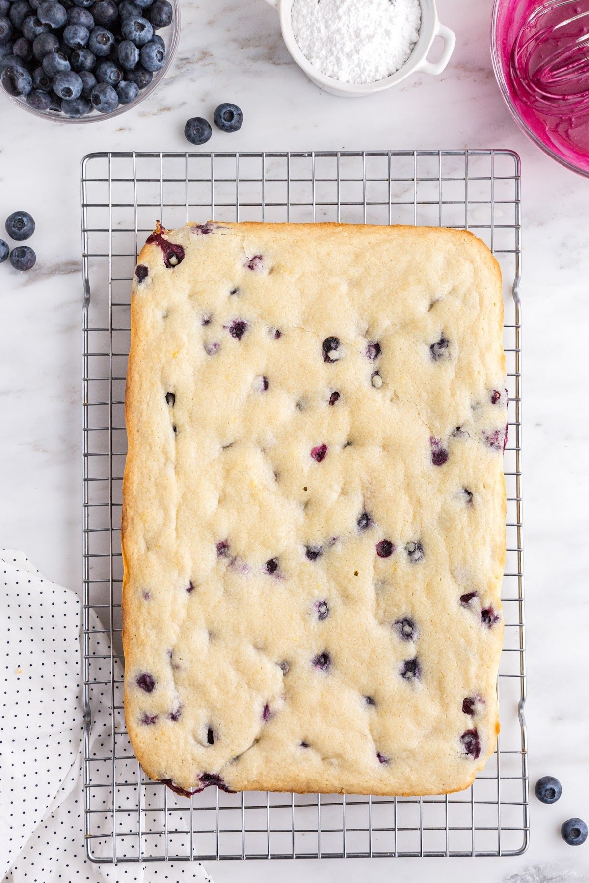 Fully baked blondies cooling on a wire rack.