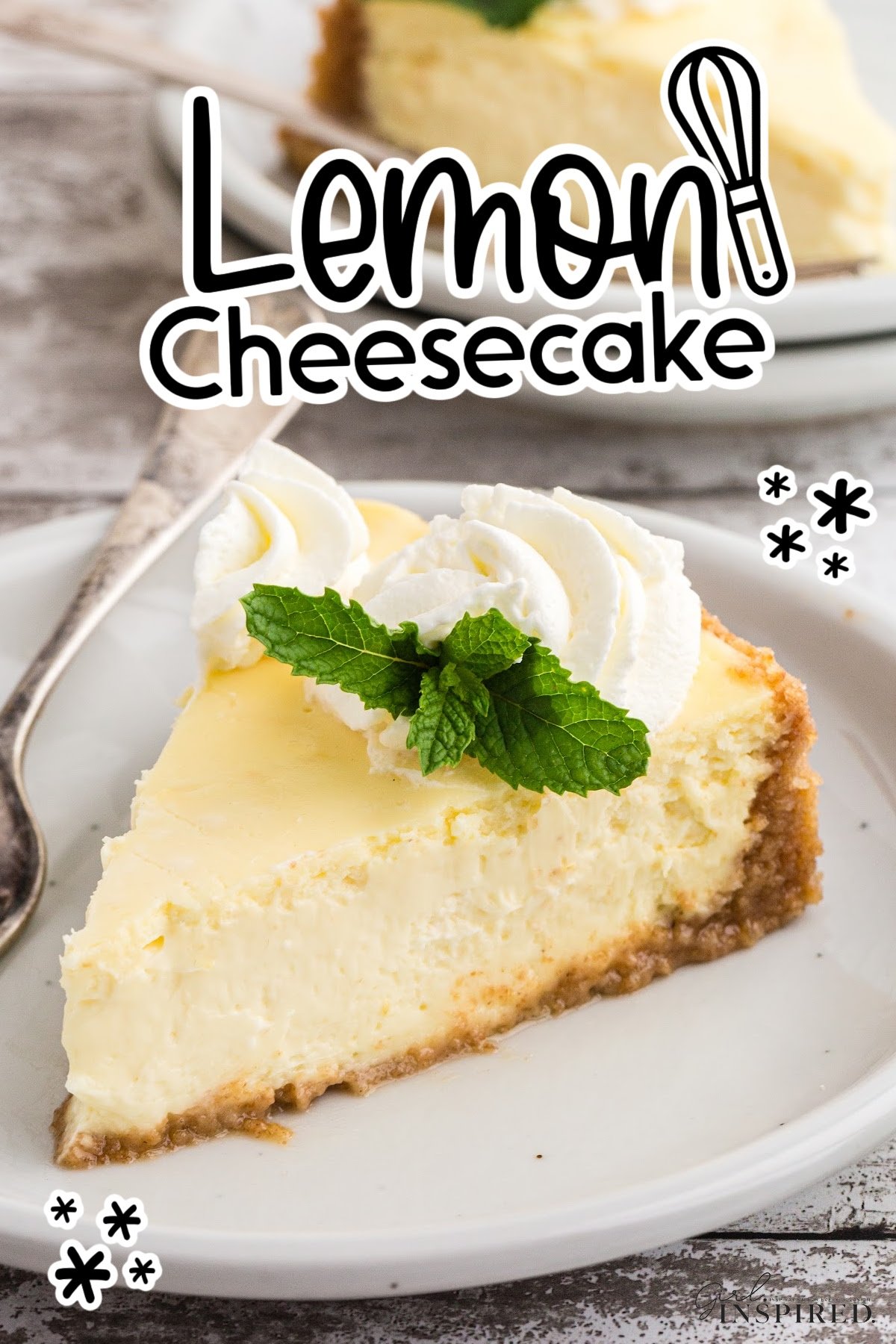 A slice of lemon cheesecake on a plate garnished with whipped cream and mint.