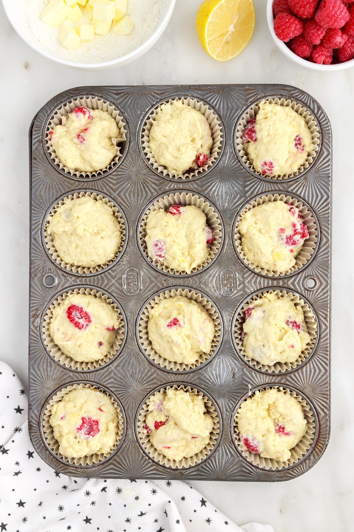Lined muffin tin filled with Raspberry Lemon Muffin batter.