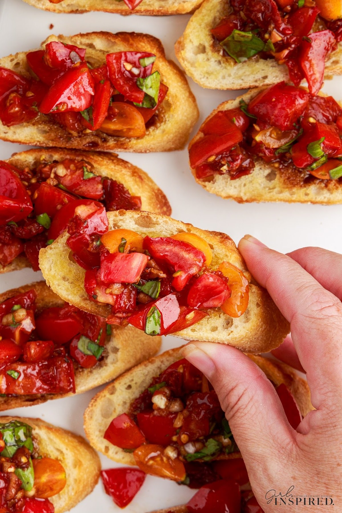 Picking up a piece of Sundried tomato bruschetta from the serving tray.