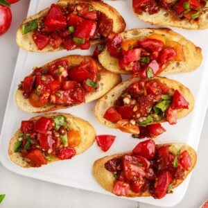 Sundried tomato bruschetta on a white serving tray.