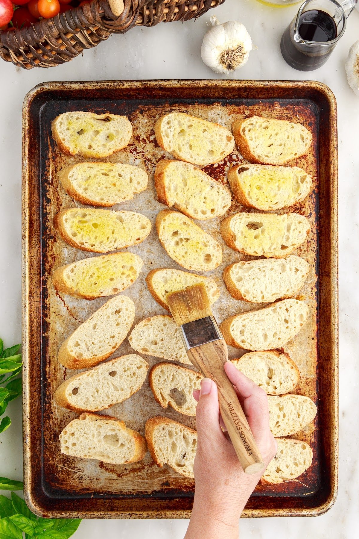 Brushing the bread slices with oil before baking.