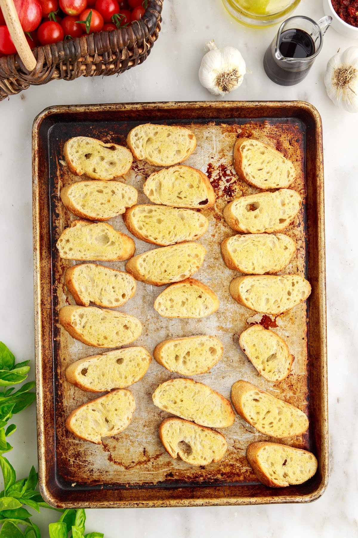 Toasted baguette slices on a baking sheet.