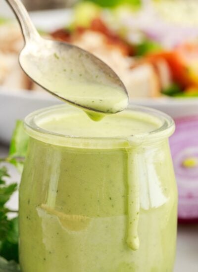 Cilantro Lime Dressing in a glass jar and a spoonful above it.