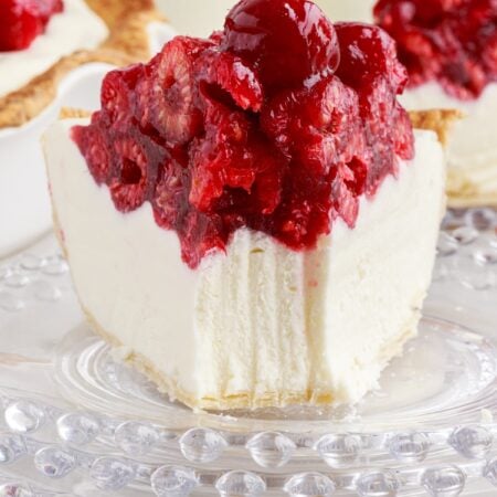 A slice of Raspberry Cream Cheese Pie on a plate with a fork mark taking out.