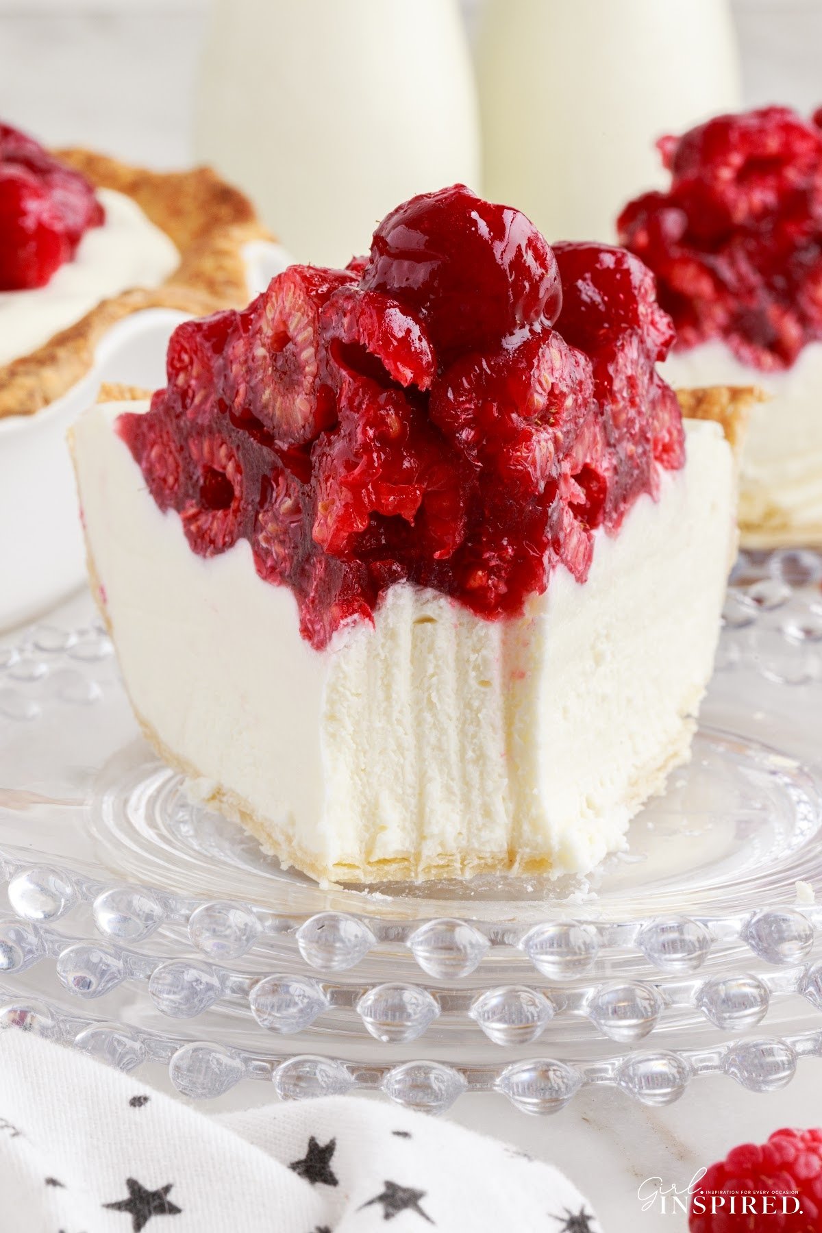 A slice of Raspberry Cream Cheese Pie on a plate with a fork mark taking out.