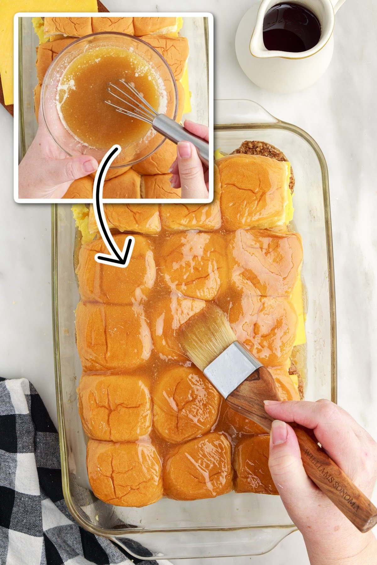 Brushing butter on the top of the bread rolls.