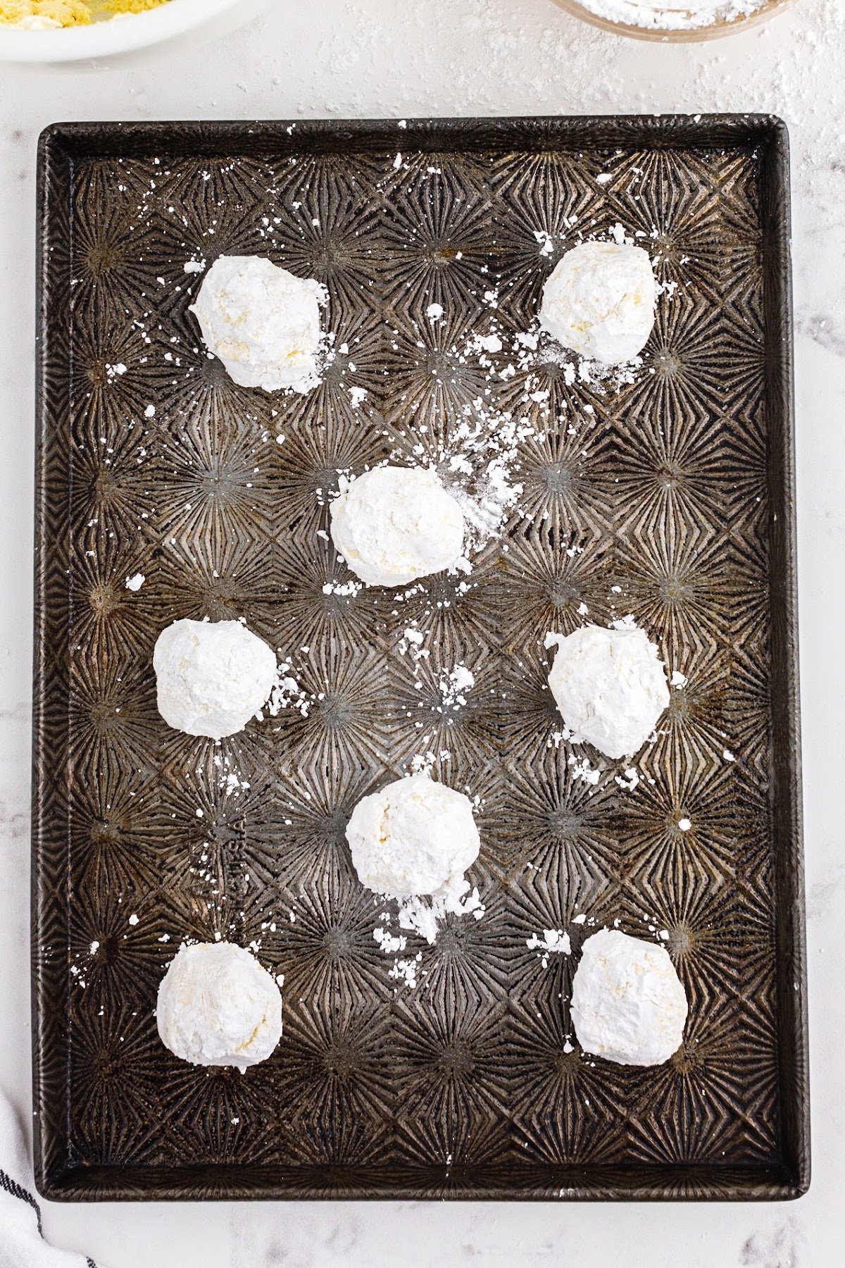 Rolled cool whip cookies in powdered sugar.